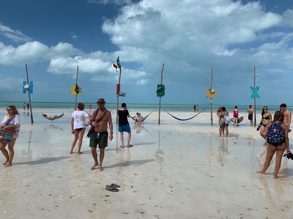 travelers enjoy holbox island hammocks in the water